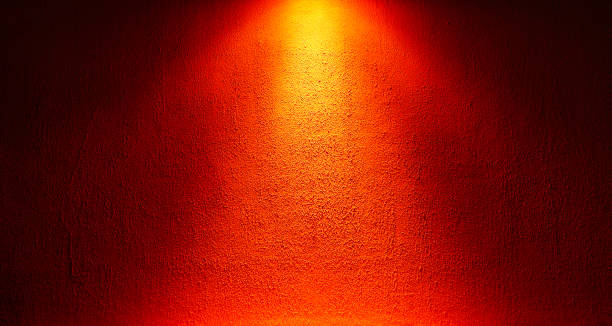 la parete è illuminata dall'alto da una luce rossa. sfondo o trama astratta. - red spotlight foto e immagini stock