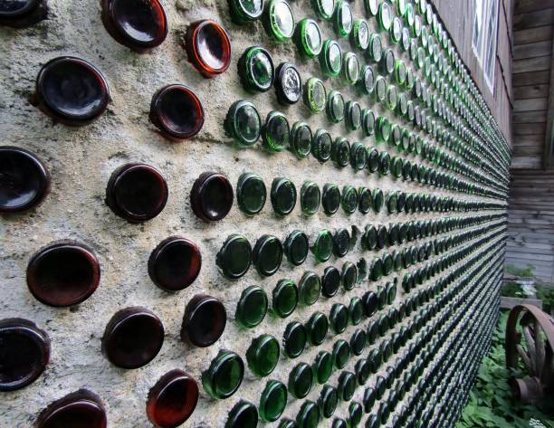 Wall made of glass bottles House wall made of glass bottles upcycling stock pictures, royalty-free photos & images