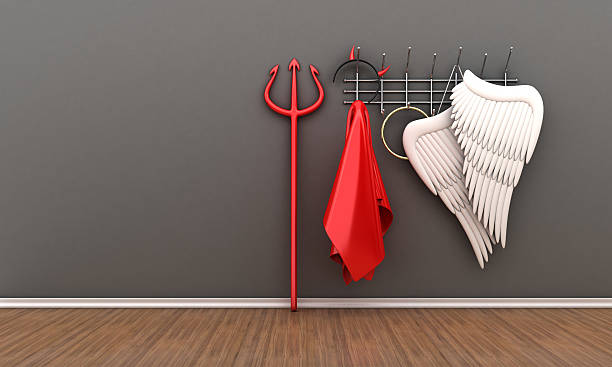 Wall mounted clothes hook with angel and devil costumes  stock photo