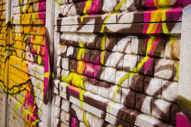 Wall with pink and yellow graffiti urban scene stock photo