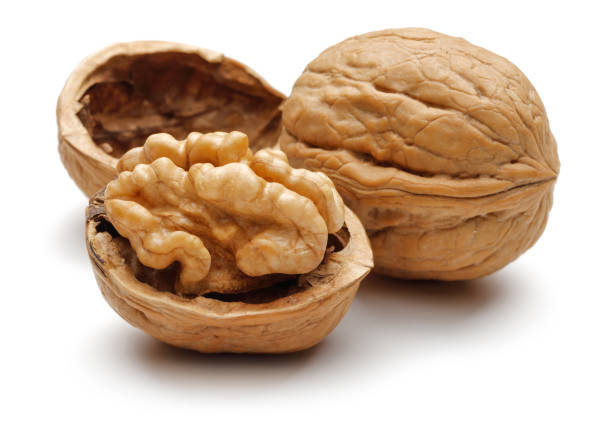 walnuts and cracked walnut on white background - nozes imagens e fotografias de stock
