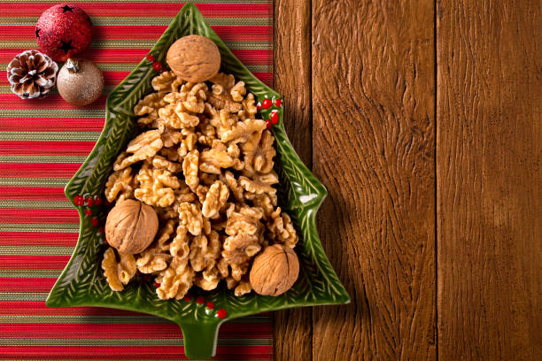 Walnuts in a Christmas Tree Pot on a wood background. Top View. Walnuts in a Christmas Tree Pot on a wood background. Top View nut food stock pictures, royalty-free photos & images