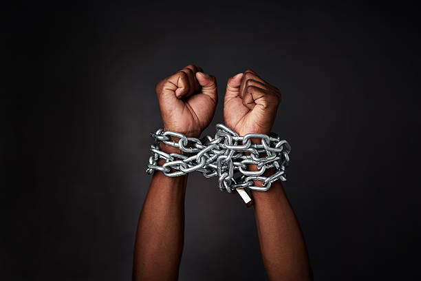 I want to break free Cropped shot of a man’s hands tied up with chains against a black background hands tied up stock pictures, royalty-free photos & images