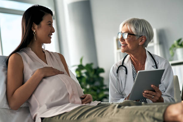I want to introduce you to this helpful app Cropped shot of a pregnant woman having a consultation with a female doctor gynecologist photos stock pictures, royalty-free photos & images