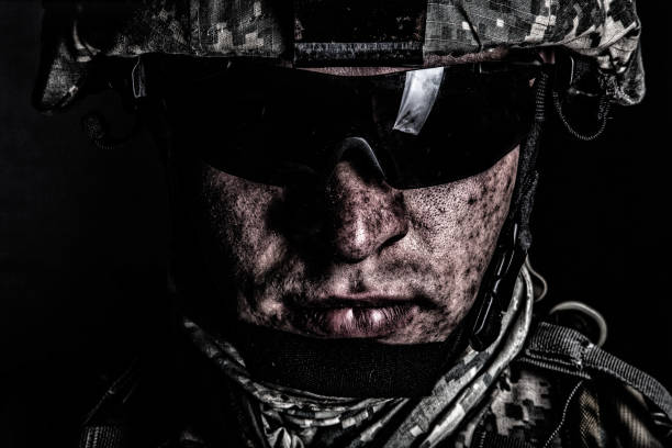 War conflict combatant after battle or raid Cropped close up portrait of US special operations forces soldier, marine raider, modern combatant in helmet and glasses with dirty face after difficult military mission or battle looking at camera special forces stock pictures, royalty-free photos & images