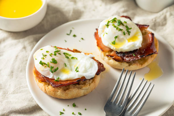 Warm Homemade Eggs Benedict Warm Homemade Eggs Benedict with Ham and Hollandaise poached food stock pictures, royalty-free photos & images