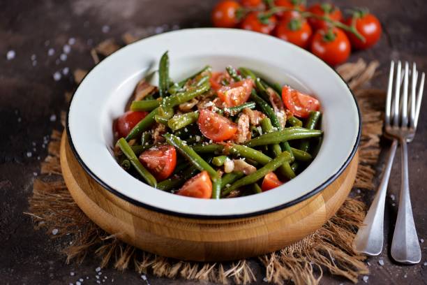 Warm salad of green beans Warm salad of green beans, cherry tomatoes with fried bacon and parmesan cheese. green bean stock pictures, royalty-free photos & images