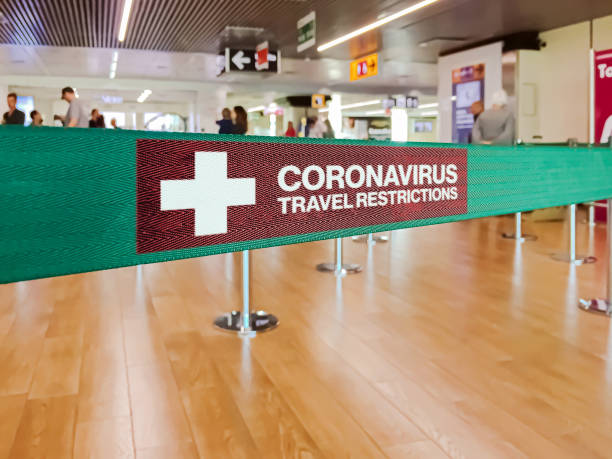 Warning of travel restriction in airport Green ribbon barrier inside an airport with the warning of travel restrictions due to the spread of the dangerous Coronavirus travel stock pictures, royalty-free photos & images