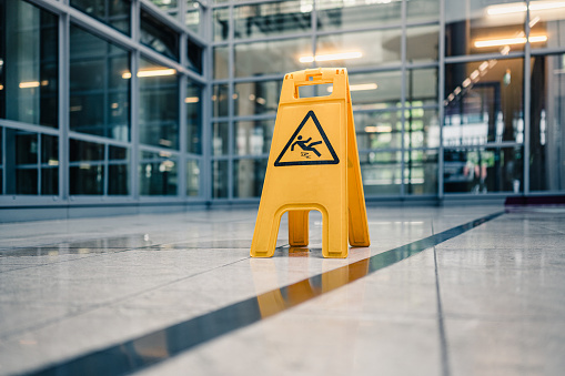 Yellow sign on floor that alerts for wet floor.