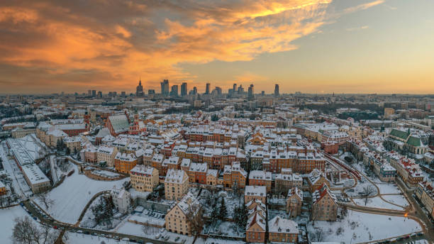 Warsaw old town, snow-covered roofs and and distant city center at dusk, aerial winter panorama stock photo