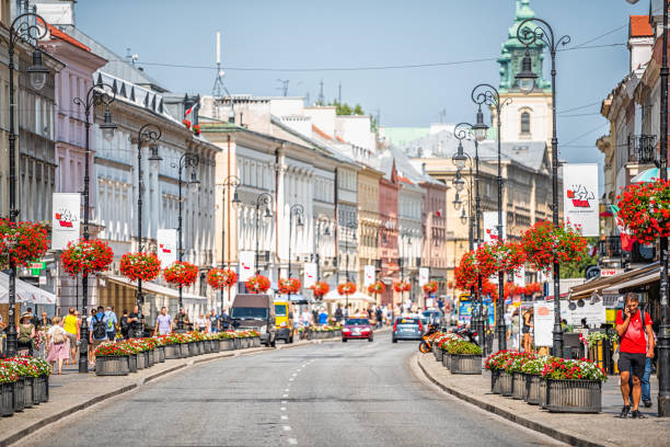 Warsaw, Poland Krakowskie Przedmiescie street in capital city during sunny summer day with red potted flower baskets stock photo