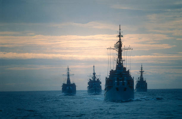 Warships Four frigates doing an exercise on the ocean at the end of the day.I used a slide film battle stock pictures, royalty-free photos & images