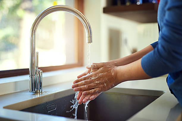 Washing up before dinner Shot of an unrecognizable woman washing her hands in the kitchen sink sink stock pictures, royalty-free photos & images