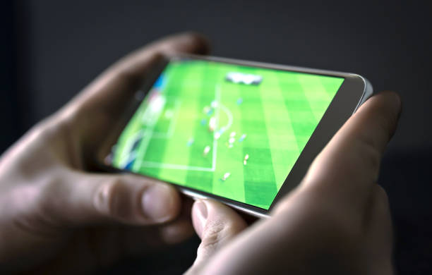 kijken naar voetbal en sport stream met mobiele telefoon. man streaming voetbal spel live, video afspelen of hoogtepunten online met smart device. - kijken naar stockfoto's en -beelden