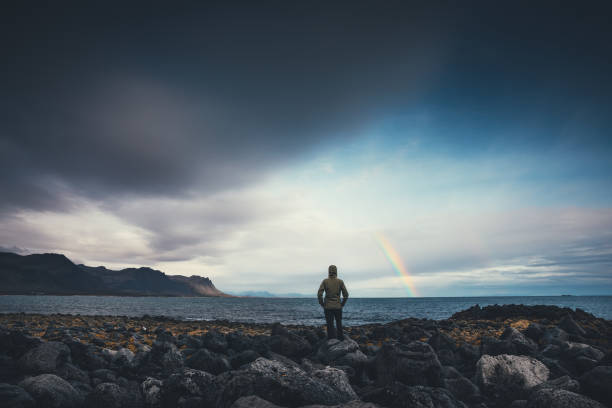 kijken naar de regenboog in ijsland - rain woman sun stockfoto's en -beelden