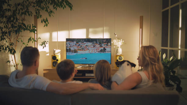 Watching tv at home. Family with two sons spending time together stock photo