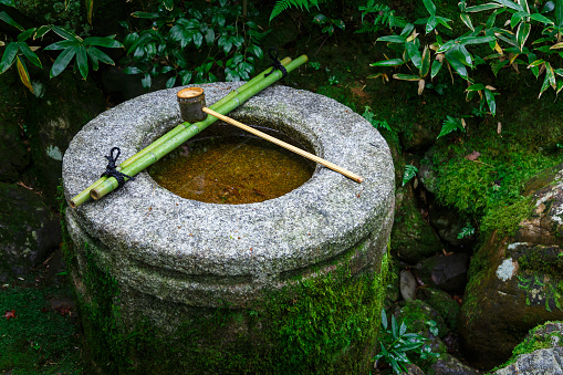 Water Dipper Auf Einem Stein Basin In Einem Japanischen Garten