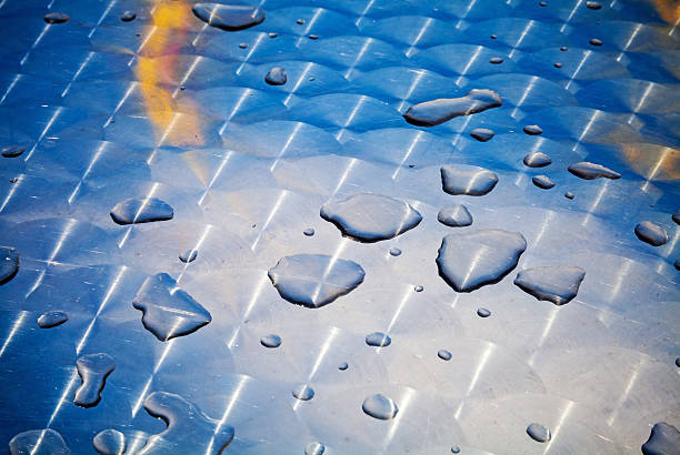 Texture of water drops on shining metal table surface with scratches...