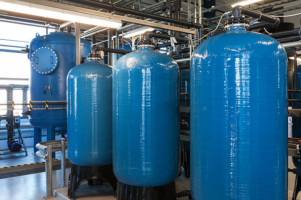 Water filter warehouse with four large blue tanks stock photo