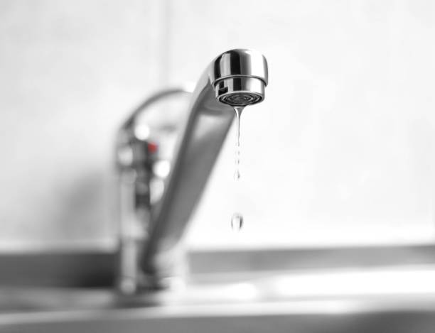 Water is dripping from a metal water tap. Close up Water is dripping from a metal water tap. Close up. leaking stock pictures, royalty-free photos & images