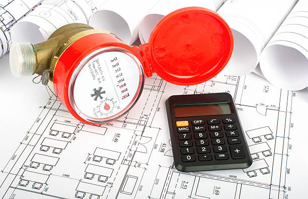 Water meter with calculator on blueprint stock photo