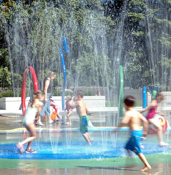 Water park Kids running in a water park - motion blur. Taken at Rocky point park, Port Moody, BC. spray park stock pictures, royalty-free photos & images