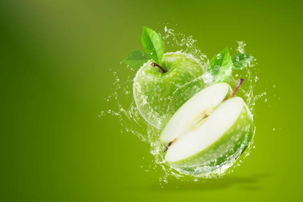 Water splashing on Fresh green apple on Green background stock photo