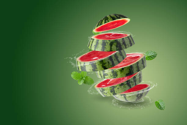 Water Splashing on Fresh Watermelon isolated on green background stock photo
