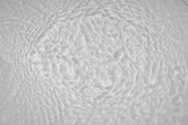 Water tranquil ripple background. Water texture, circles and bubbles on a liquid white surface. Cosmetic products and flat design concept stock photo