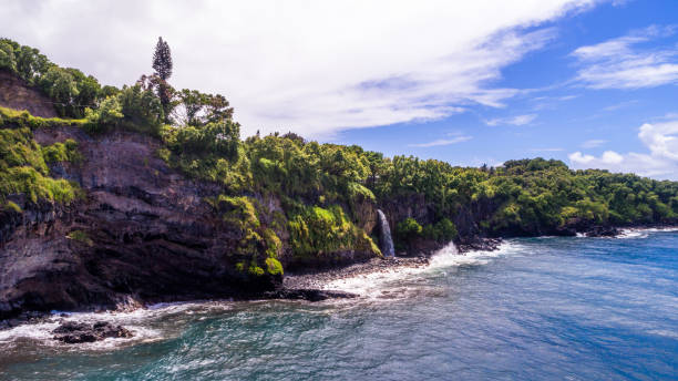 Waterfalls cascading down the cliffs over pasific ocean, Hawaii stock photo