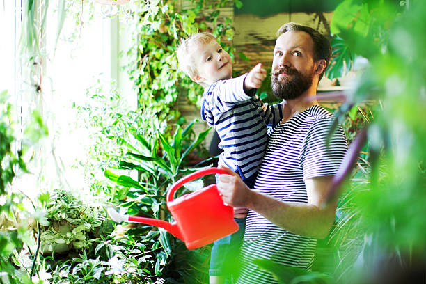 Watering Father and son watering flowers gardening equipment photos stock pictures, royalty-free photos & images