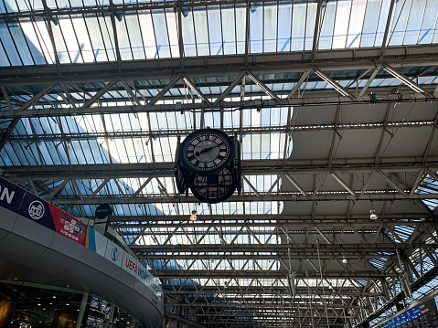 The Clock hanging up of London Waterloo Station. View of hall of Waterloo train station, terminal station for trains to South-West London and South England. Modern glass building. Public transportation
