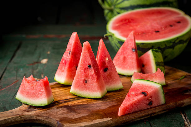 watermelon sliced on wood background - watermeloen stockfoto's en -beelden