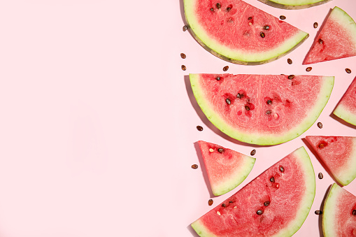 Watermelon slices on pink background, flat lay. Space for text