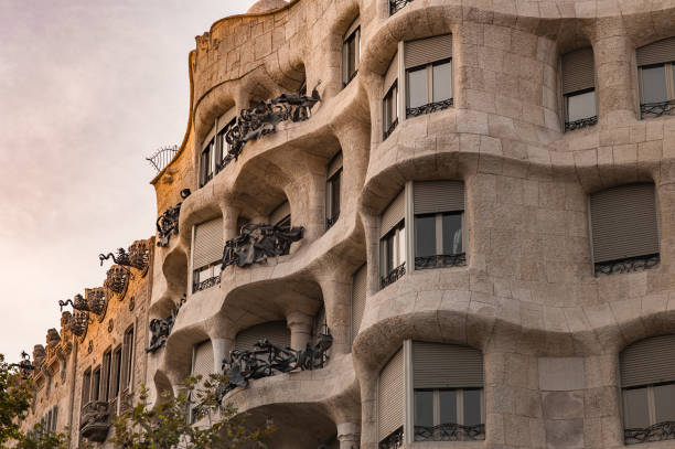 Waves and sculptural building details of La Pedrera, Casa Mila in Barcelona, Spain. Barcelona, Spain - September 8, 2017: Ornate architecture, view from below at sunset, vibrant colours and twisting shapes of Antonio Gaudi. casa milà stock pictures, royalty-free photos & images