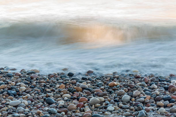 Waves rushing over stones on a Lake Huron beach stock photo