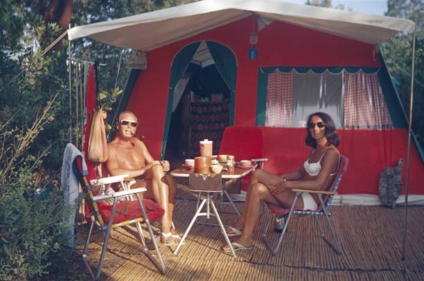 We also love camping Provence, Southern France, 1970. A couple enjoys their camping holiday over a cup of coffee on the Côte d'Azur. camping photos stock pictures, royalty-free photos & images