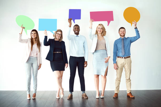 We are loud and proud! Shot of a group of work colleagues standing next to each other while holding speech bubbles against a white background speech bubble photos stock pictures, royalty-free photos & images