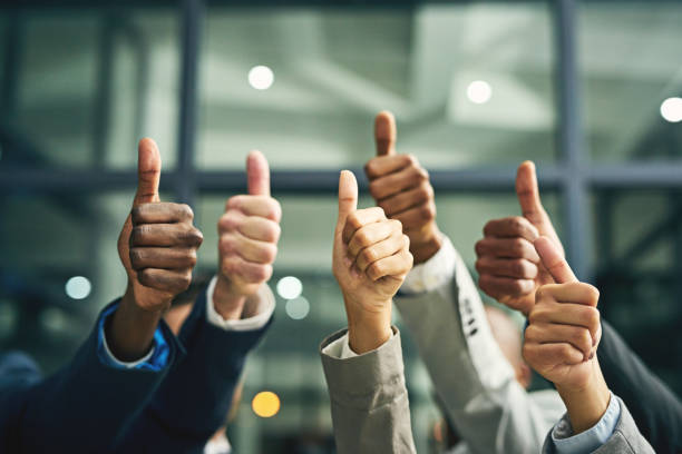 We couldn't agree more! Closeup shot of a group of unidentifiable businesspeople showing thumbs up in an office business thumbs up stock pictures, royalty-free photos & images