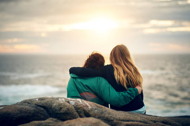 We embrace each other as we embrace nature Shot of unrecognizable female friends looking at the view together outdoors arm around stock pictures, royalty-free photos & images