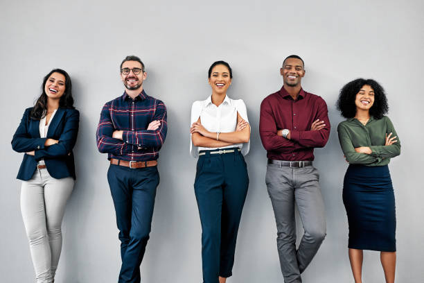 We put the human in human resources Studio shot of a group of businesspeople standing in line against a grey background recruitment photos stock pictures, royalty-free photos & images