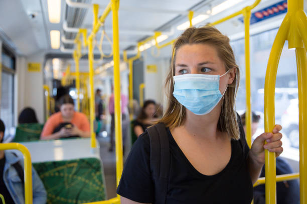 het dragen van een gezichtsmasker op de tram - openbaar vervoer stockfoto's en -beelden