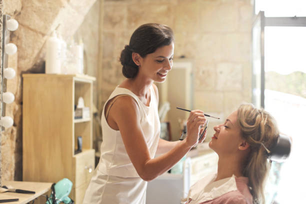Wearing make up Professional make up artist taking care of a customer makeup artist on working stock pictures, royalty-free photos & images