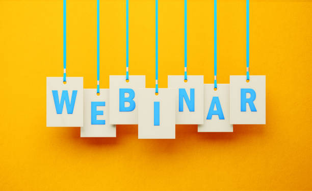 Webinar Writes on White Price Tag Hanging from Blue Ribbons over Yellow Background Webinar on white price tag hanging from blue ribbons over yellow background. Horizontal composition. Webinar concept. web conference stock pictures, royalty-free photos & images