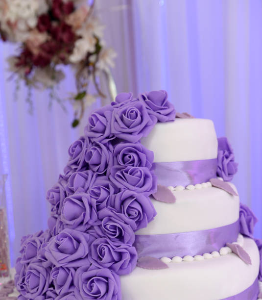 Wedding cake decorated with purple rose flowers stock photo
