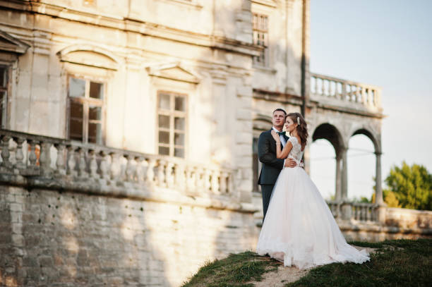 Wedding couple in love Fabulous wedding couple posing in front of an old medieval castle in the countryside on a sunny day. fiancé stock pictures, royalty-free photos & images