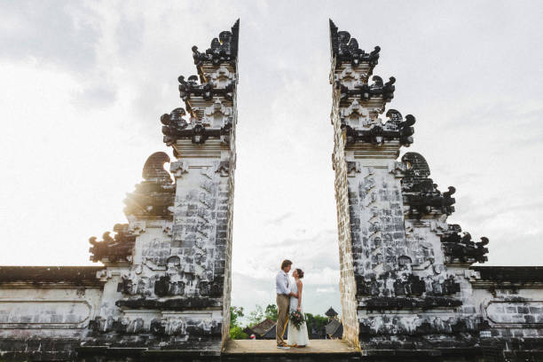 bruidspaar in pura lempuyang tempel in bali. beroemde indonesische bezienswaardigheid, traditionele balinese poort. - castle couple stockfoto's en -beelden