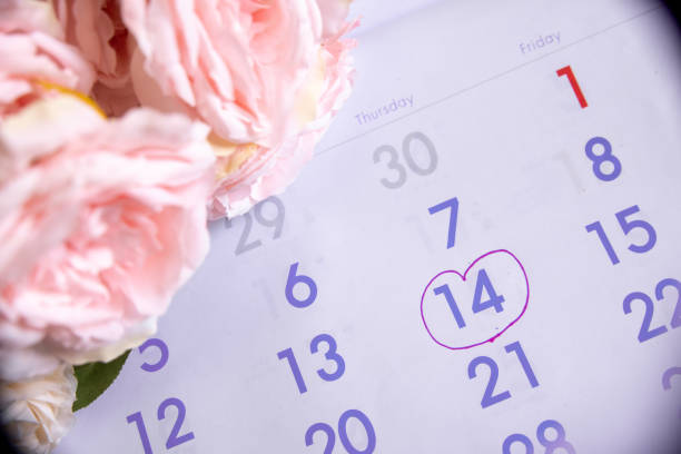 Wedding date anniversary calendar and blue flower bouquet.Couple of love  planning a honeymoon next month. stock photo