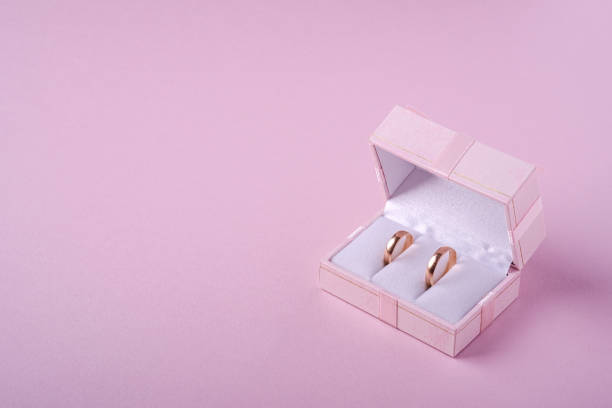 Wedding gold rings in pink gift box on soft pink background, angle view, copy space Wedding gold rings in pink gift box on soft pink background, angle view, copy space wedding ring box stock pictures, royalty-free photos & images