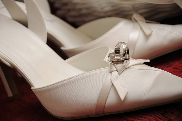 Wedding rings on white high heels stock photo